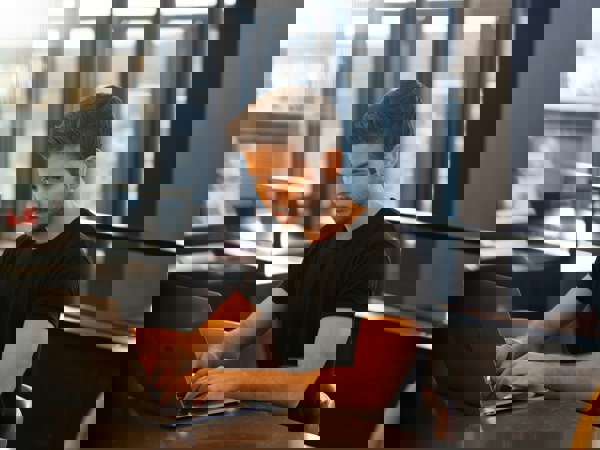 a person sitting at a table using a laptop