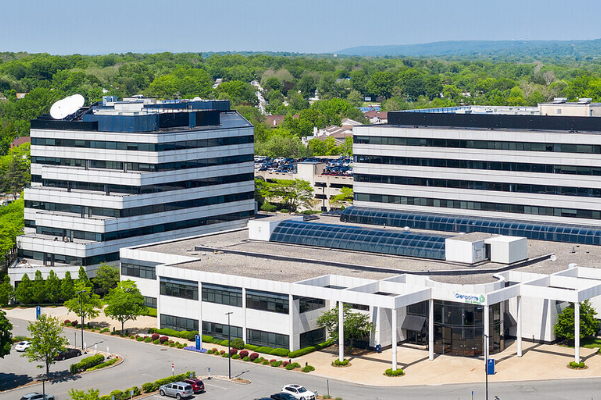 a group of buildings with trees in the background