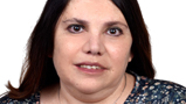 a person with dark hair wearing a floral shirt