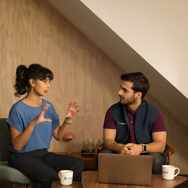 une personne et une personne assises sur une chaise avec un ordinateur portable