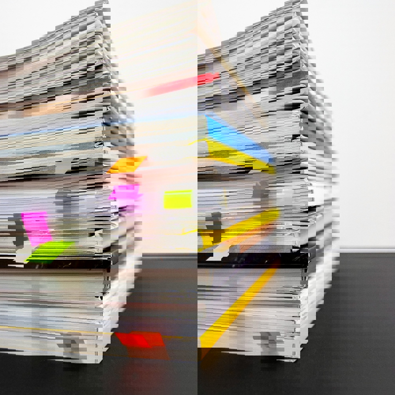 a stack of books with colorful paper clips