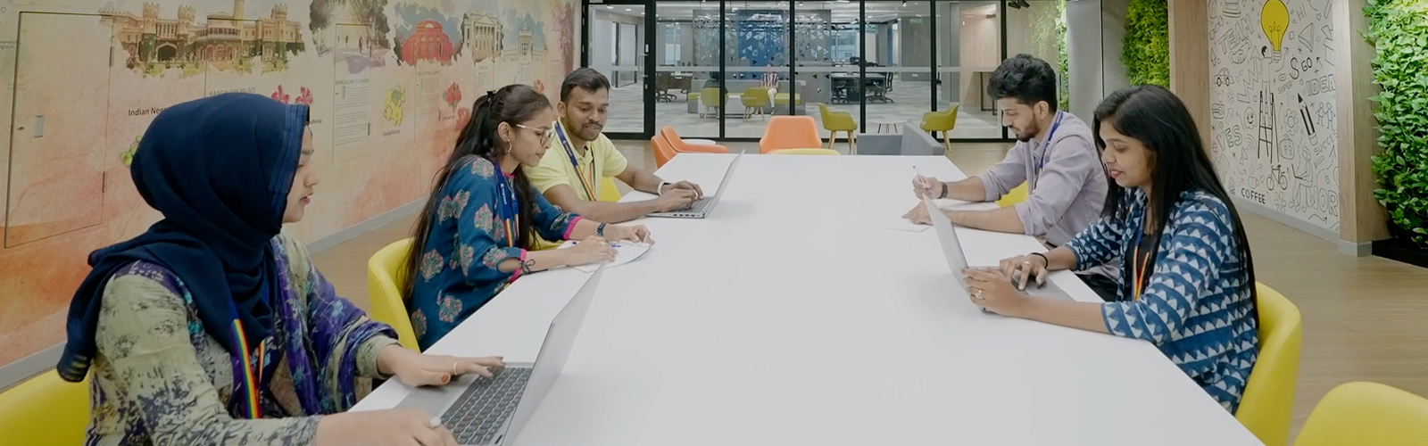 um grupo de pessoas sentadas em uma mesa com laptops