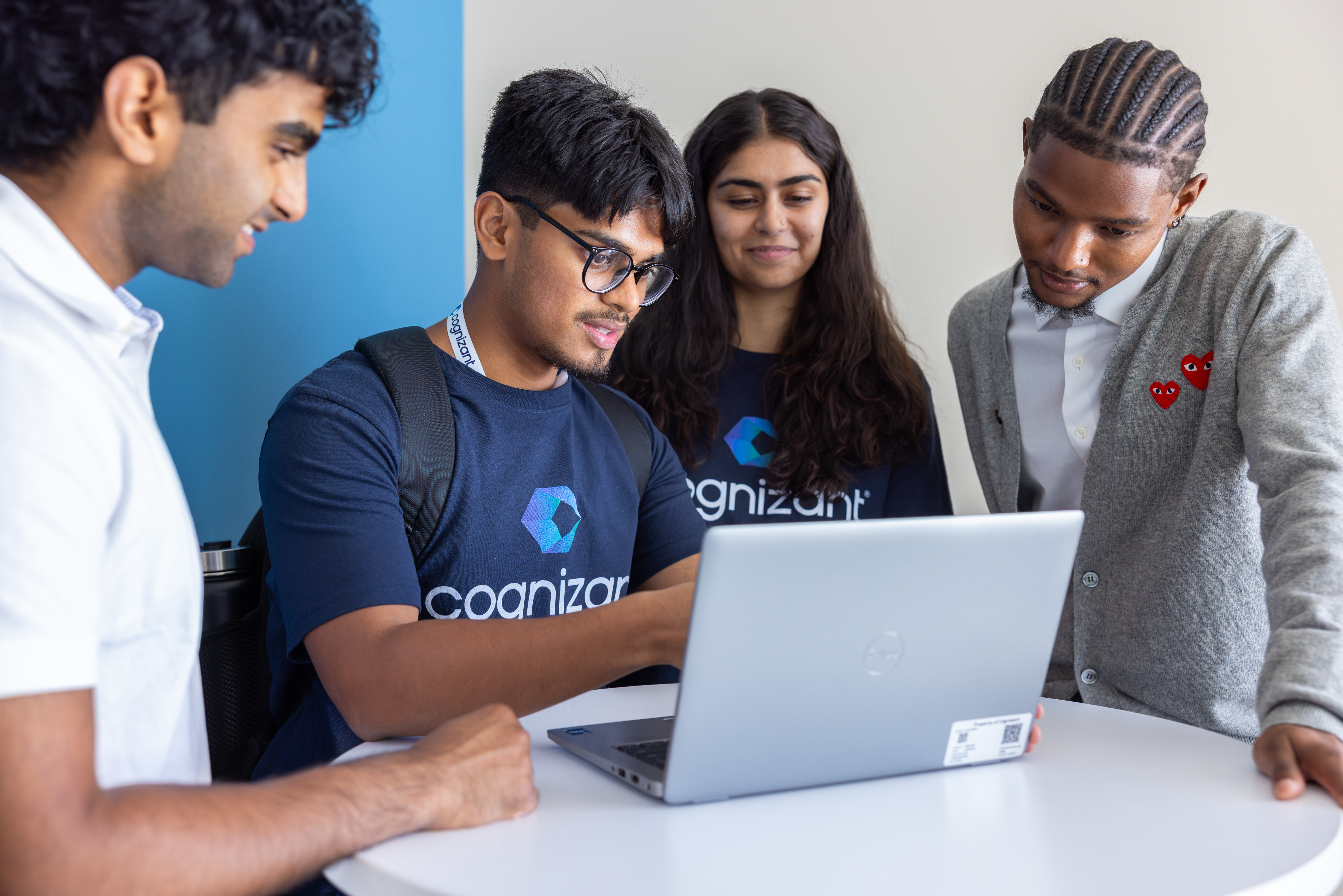 a group of people looking at a laptop