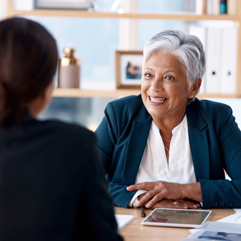 Une personne assise à une table avec une autre personne souriante