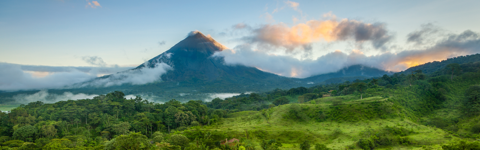 una montaña con árboles y nubes