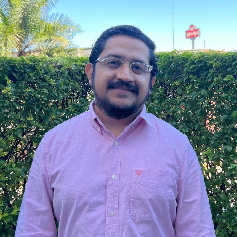 a person wearing glasses and a pink shirt