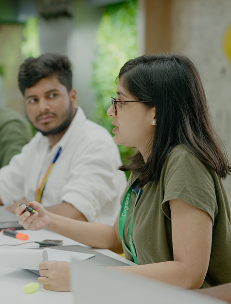 a person sitting at a table with a person in the background