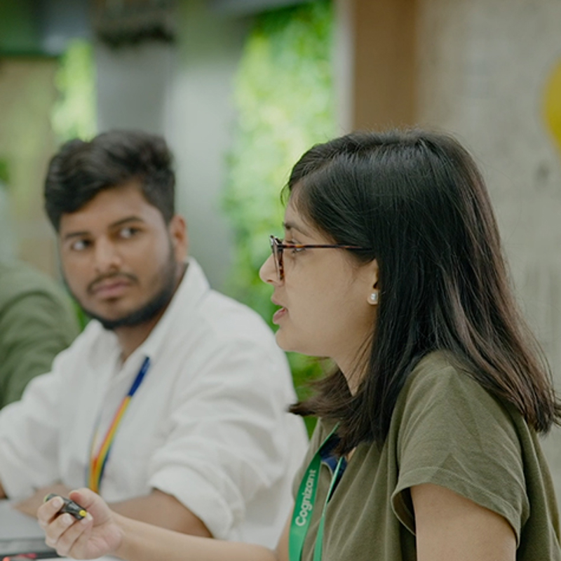 a person sitting at a table with a person in the background
