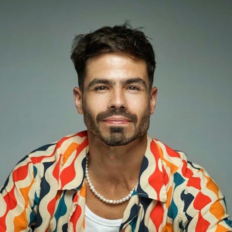 une personne avec une barbe et une moustache portant une chemise colorée