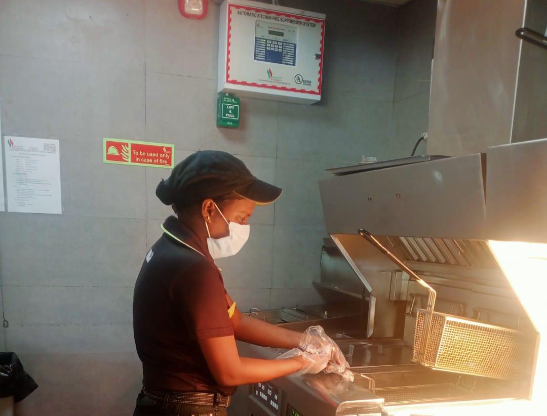 a person wearing a mask and gloves at a restaurant