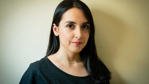 a person with long hair wearing a necklace