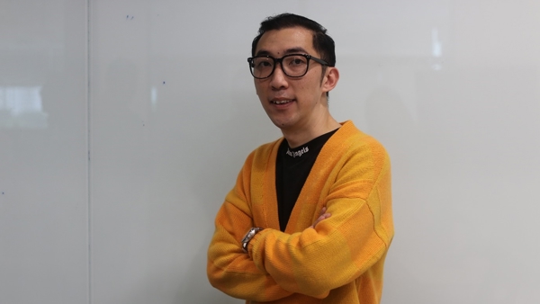a person wearing glasses and a yellow cardigan