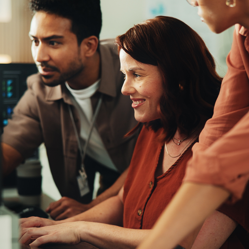 a group of people looking at a computer
