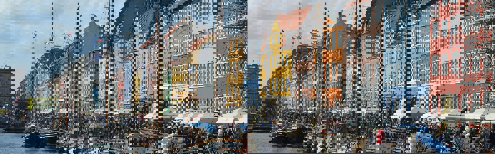 boats on the water next to a row of buildings