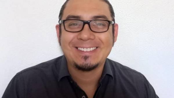 a person wearing glasses and smiling