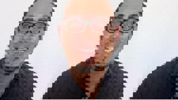a person wearing glasses and smiling