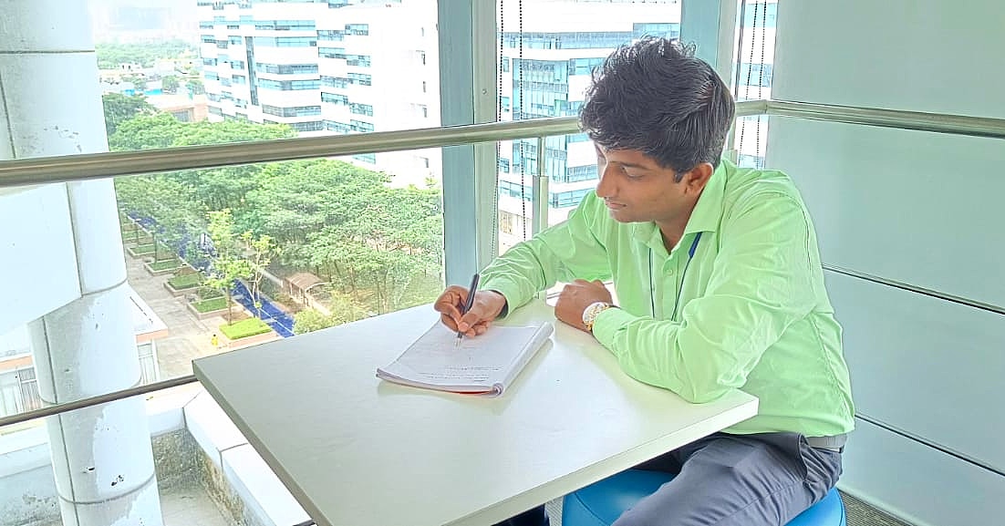 a person sitting at a table writing on a book