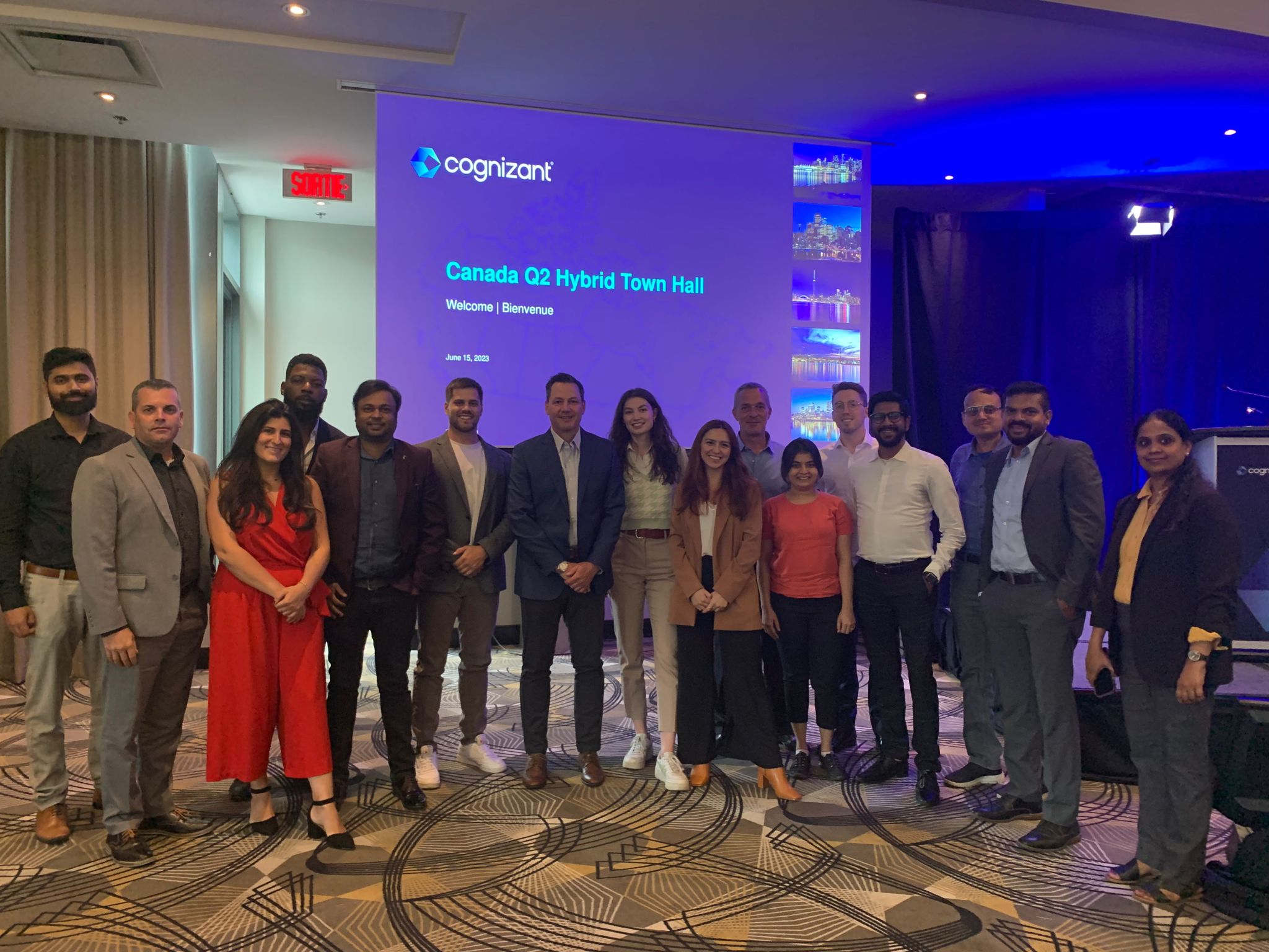 un groupe de personnes debout devant l’écran d’un projecteur