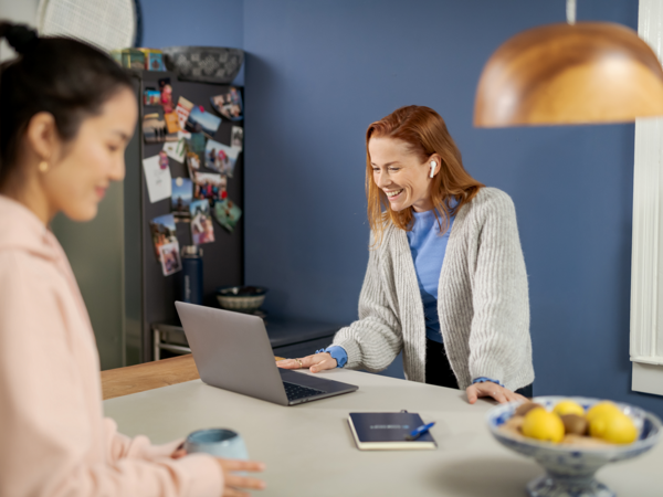 a person smiling at a laptop