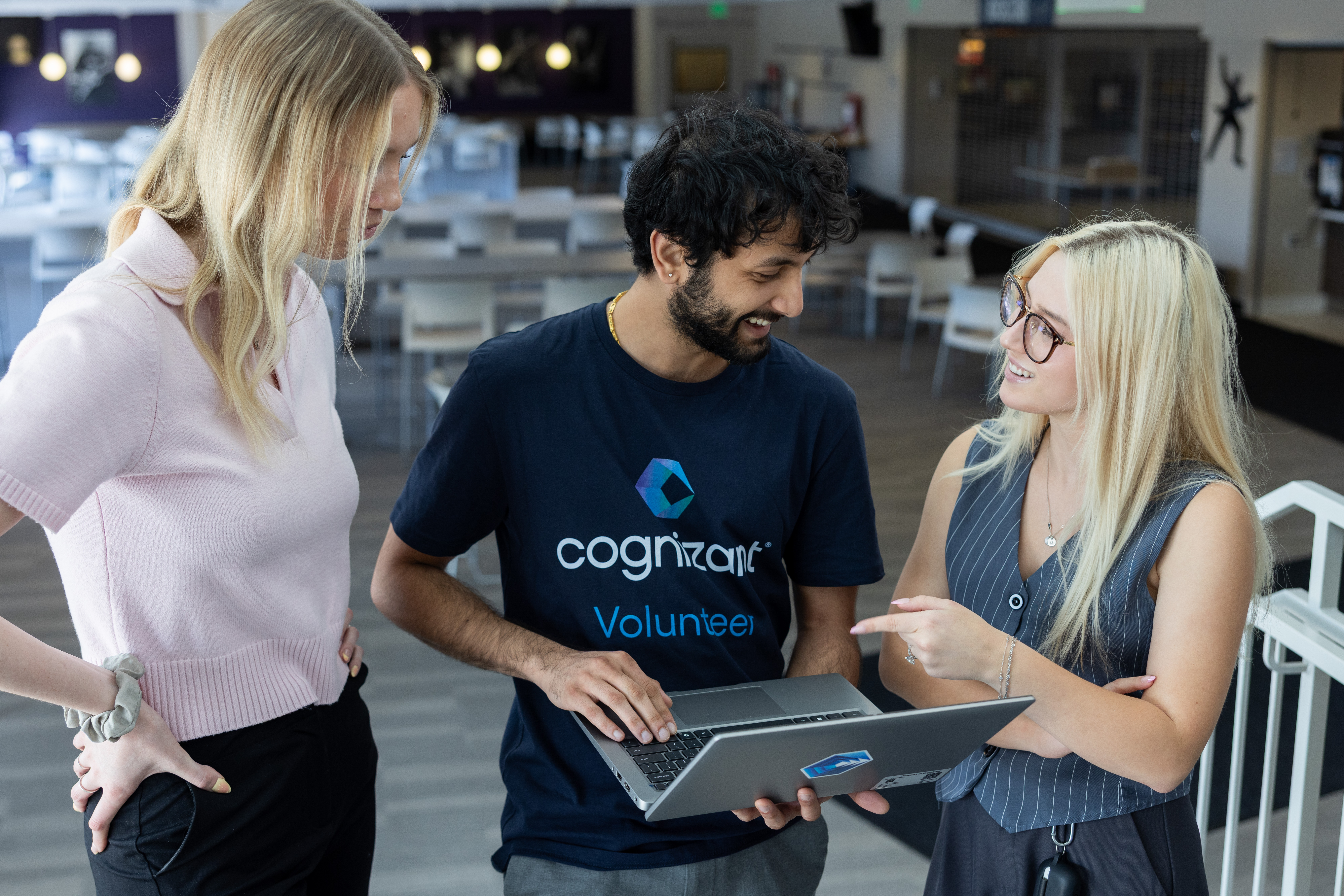 a group of people standing around a laptop