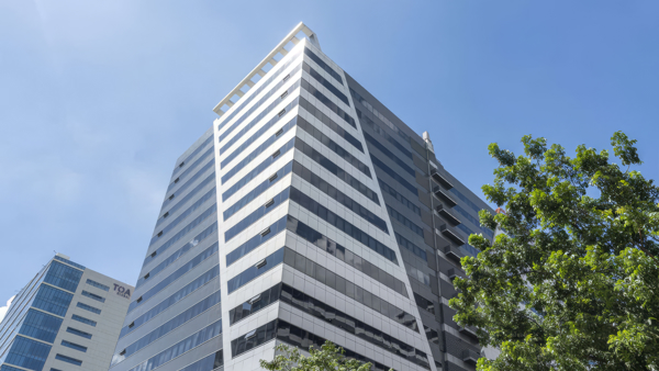 a tall building with trees and blue sky