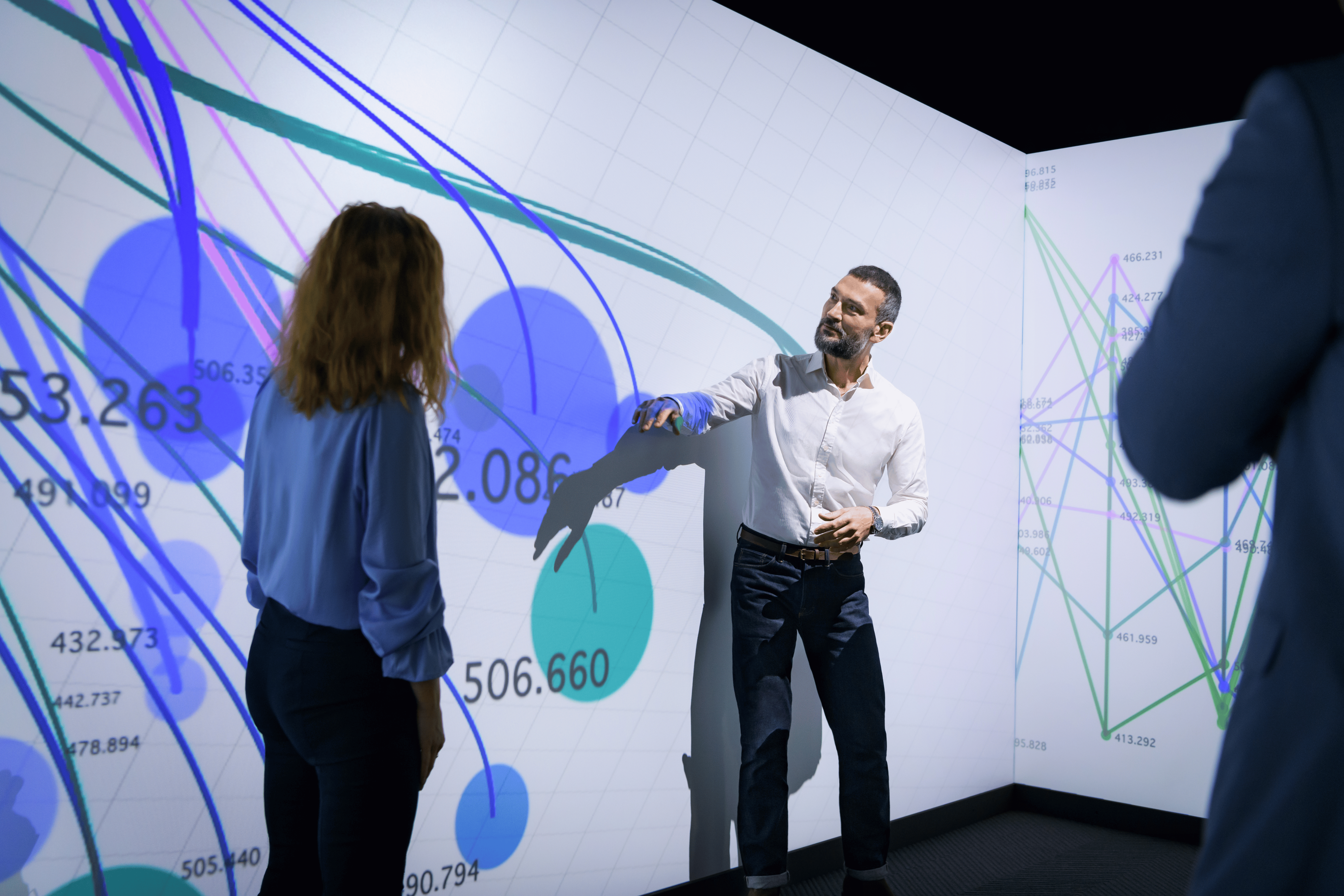 a person standing in front of a large screen with a person standing in front of him