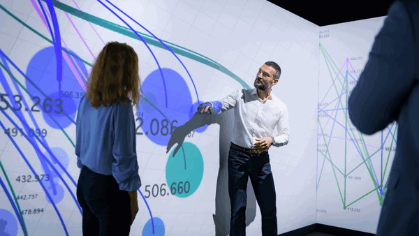 a person standing in front of a large screen with a person standing in front of him