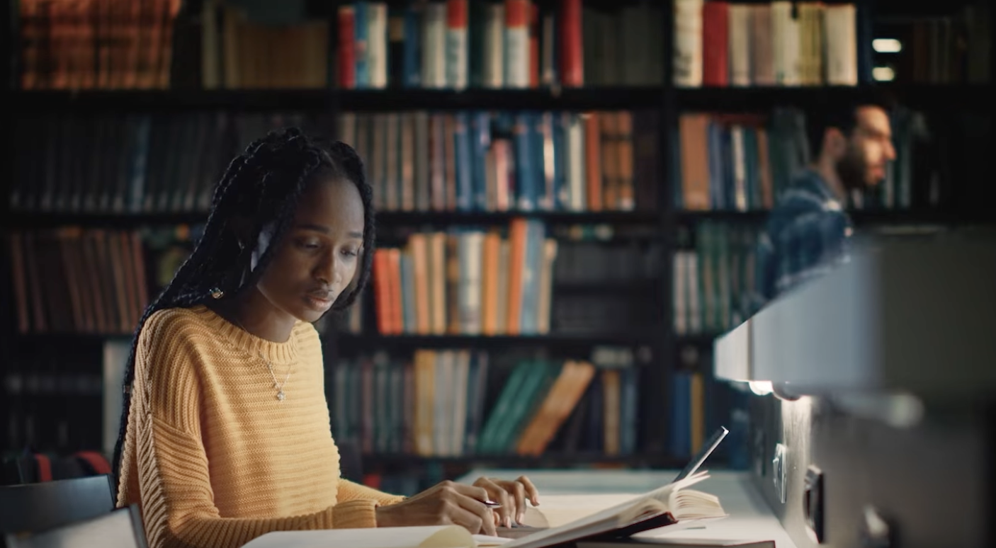 a person sitting at a desk in front of a book