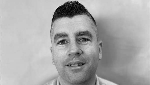 a person with short hair wearing a button up shirt