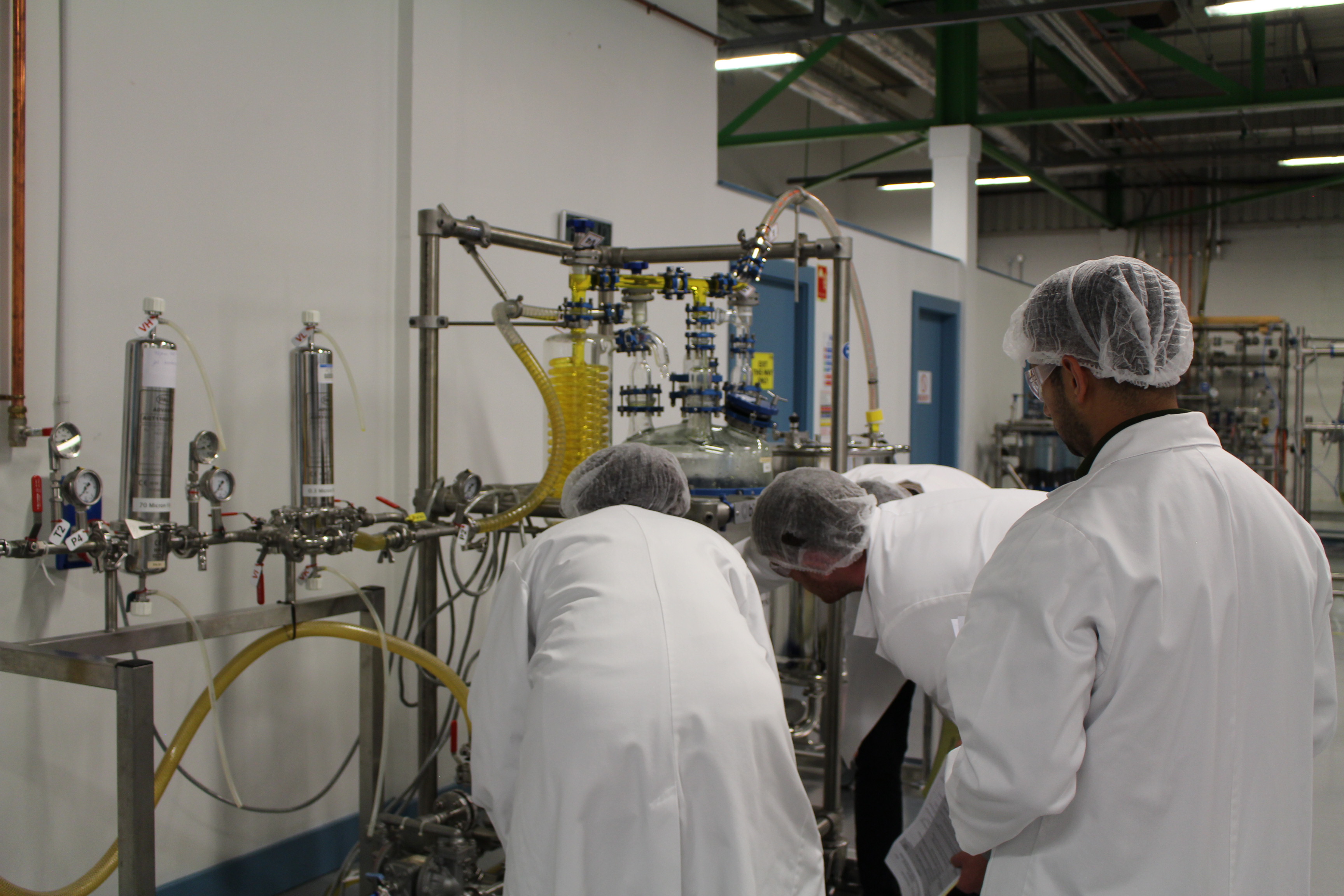 a group of people in white coats in a factory