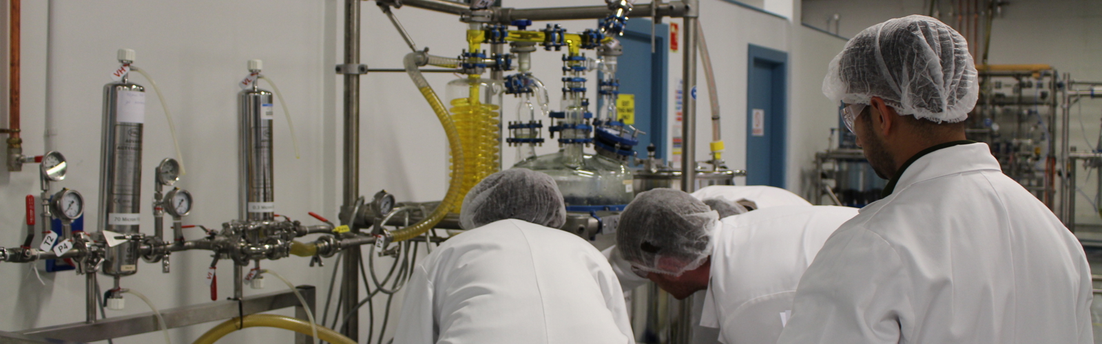 a group of people in white coats in a factory