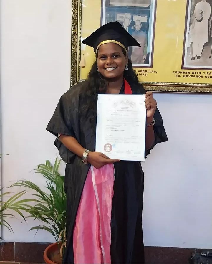 a person in a graduation gown holding a diploma