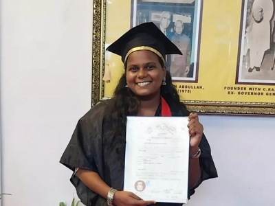 a person in a graduation gown holding a diploma