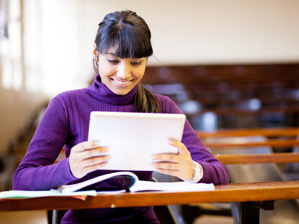 a person in a purple sweater looking at a tablet